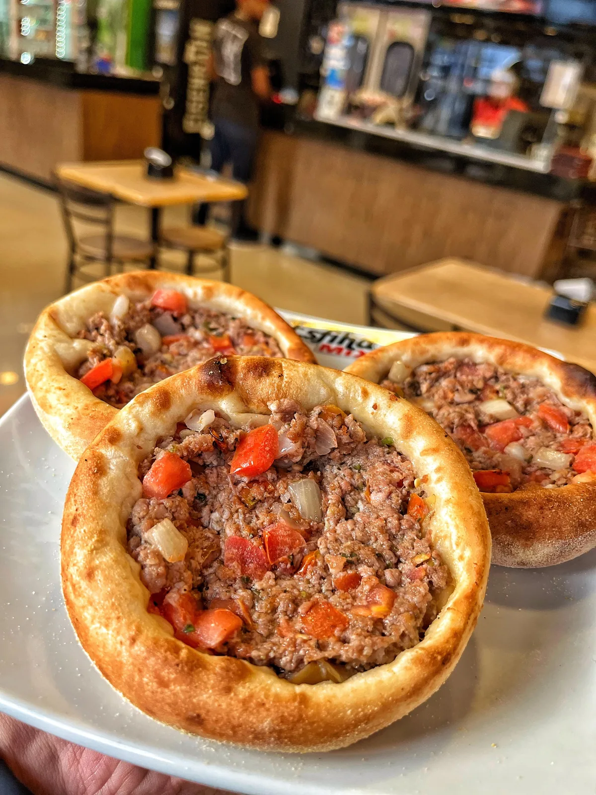 Esfihas de carne da Esfiha Mix, com uma esfiha em primeiro plano