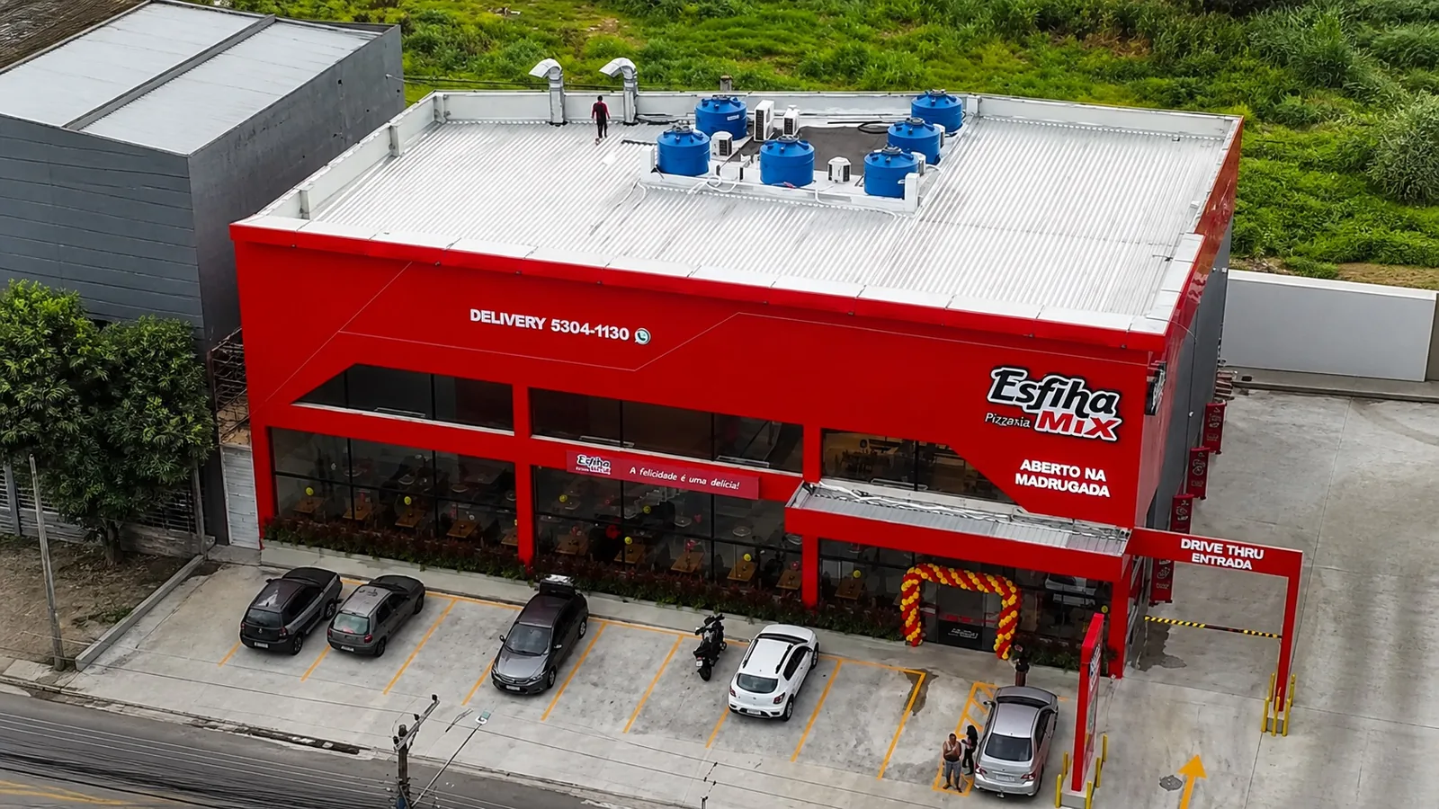 Vista aérea da unidade Esfiha Mix Ferraz de Vasconcelos, com fachada, estacionamento e drive-thru