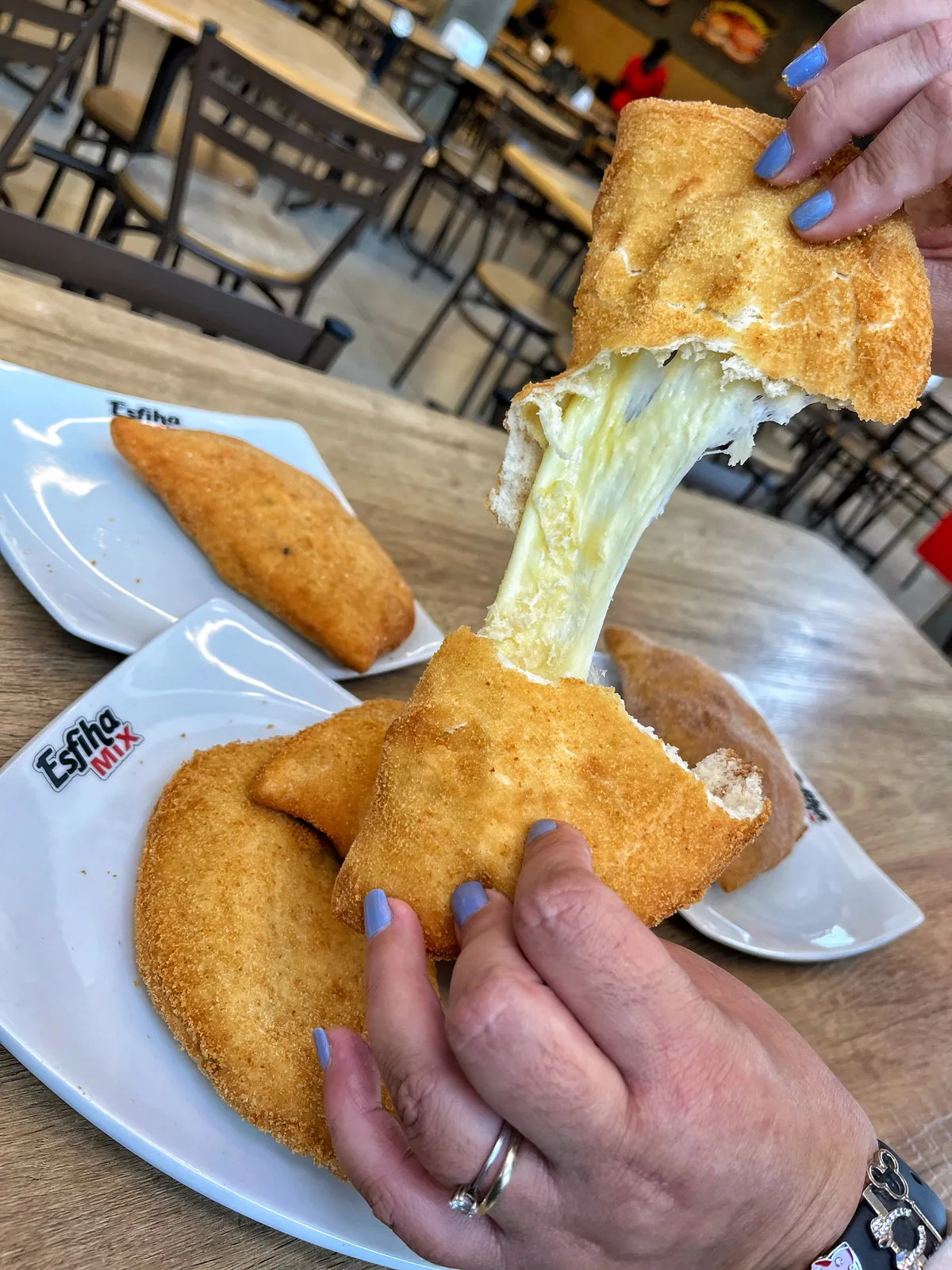 Pastel de queijo sendo aberto, com queijo derretido
